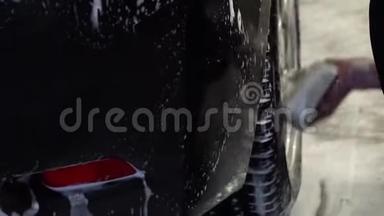 洗车一个洗车工洗车.. 一个男人用泡沫海绵洗汽车。 特写镜头。 慢动作。